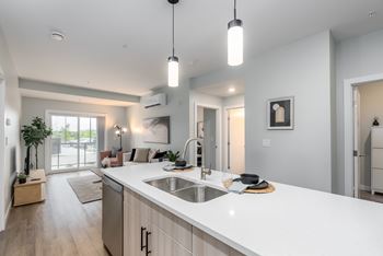 A modern kitchen with a large island and pendant lights.